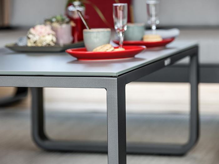 Der Loungetisch Split aus Aluminium mit einer roten Tischdekoration.